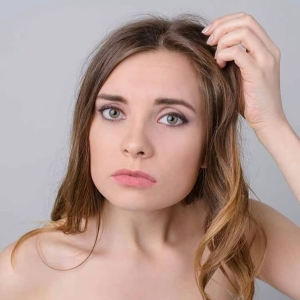 Frau fasst sich an den Kopf